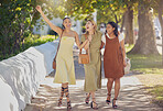 Friends, walking and park with a woman group outdoor in a formal garden for a walk together in summer. Diversity, social and friendship with a female and friend laughing or bonding outside on a path