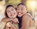 Friends, women and hug for love, care and support while outdoor for travel, happiness and bonding with asian and black woman. Lesbian couple with a smile in nature for peace, summer and time together