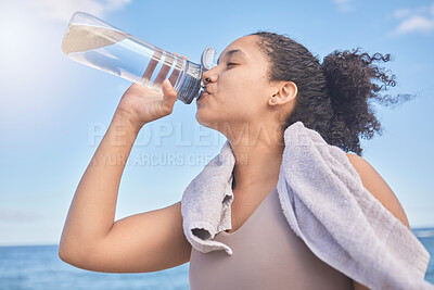 Buy stock photo Water, fitness and woman with a drink after exercise, workout or training by the sea. Sports, motivation and energy from a runner with a bottle for hydration after running by the beach in nature