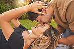 Love, park and couple kiss on picnic date to show affection, bonding and romance. Relationship, dating and young man kissing head of woman sitting on blanket, enjoying weekend, holiday and nature