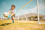 Football, boy goalkeeper and jump, saving ball from goals at outdoor sports field. Soccer, kid and competition game with fitness, goal keeper and soccer ball on grass, success and action to save goal