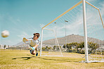 Soccer, sports and children with a goalkeeper saving a shot during a competitive game on a grass pitch or field. Football, kids and goal with a male child diving to save or stop a ball from scoring