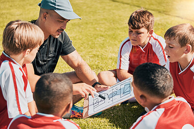 Buy stock photo Tactics, children and soccer with a coach and team talking strategy before a game on an outdoor field. Football, kids and exercise with a man training a boy sports group outside on a green pitch