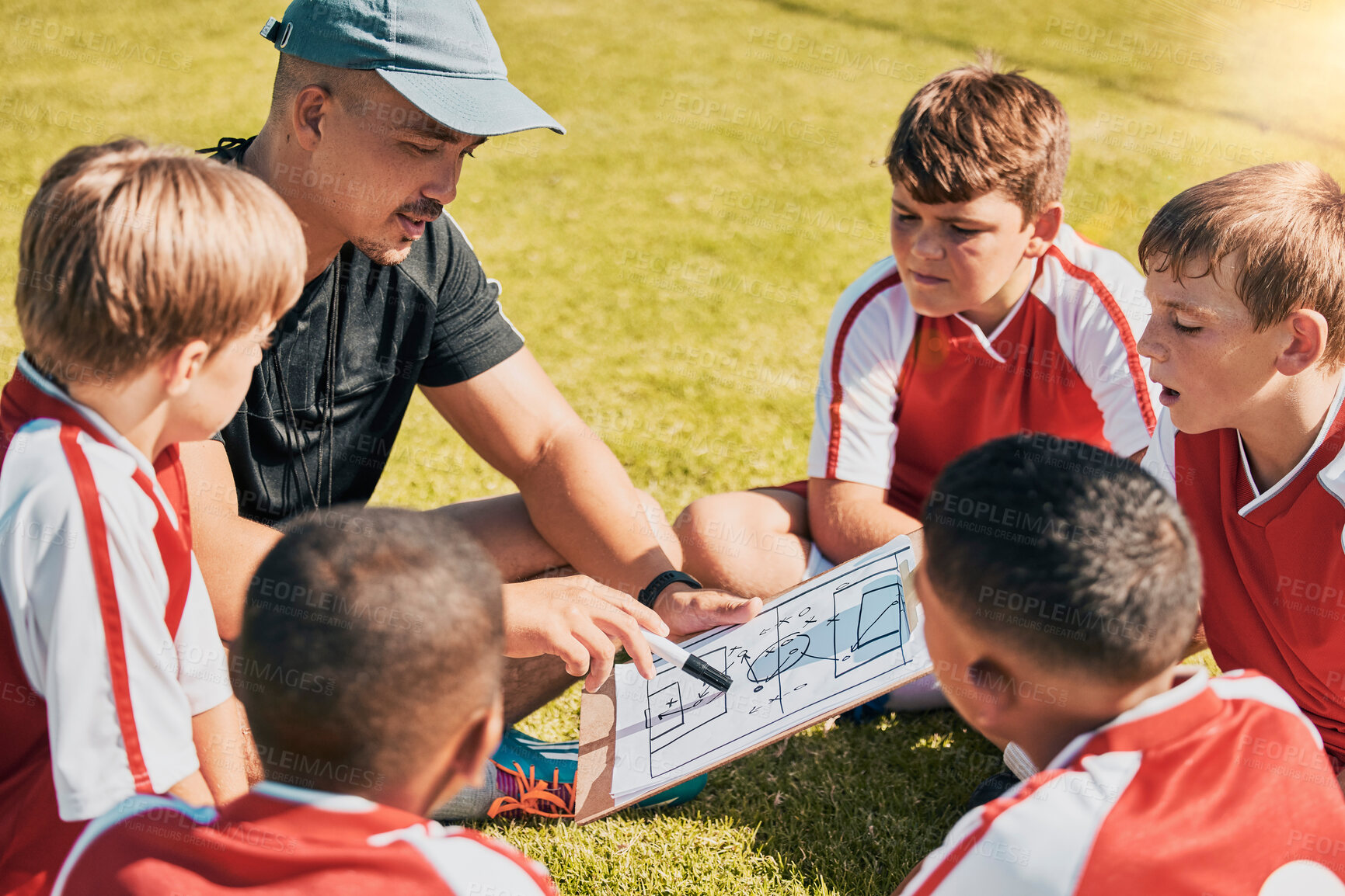 Buy stock photo Tactics, children and soccer with a coach and team talking strategy before a game on an outdoor field. Football, kids and exercise with a man training a boy sports group outside on a green pitch