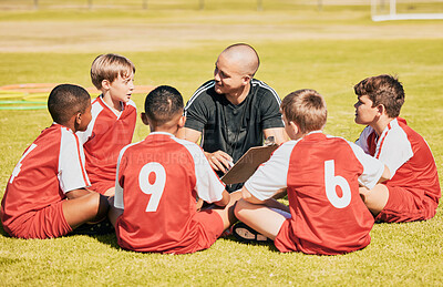 Buy stock photo kids, soccer and team coach planning training with clipboard on soccer field for sport competitiion together. Athlete children, teamwork and sit on grass before football match or workout outdoors