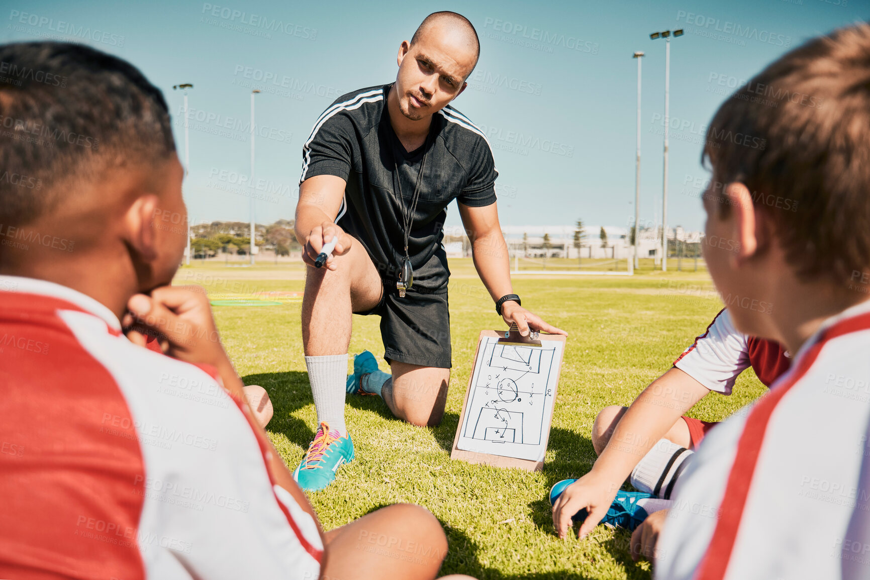 Buy stock photo Soccer team, children and coach with clipboard while talking workout plan, training and tactics on soccer field outdoor for fitness, competition and sport. Man talking to football group planning game