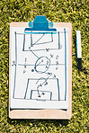 Sports, soccer field and clipboard planning a strategy for a group mission, target or tactics for goals. Solutions, teamwork and coach drawing winning tactics or ideas on grass in a football stadium