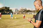 Soccer, sports and coach with a stopwatch on a field for training, check and challenge with time. Football, fitness and man reading progress of team in sport at a park for motivation in competition