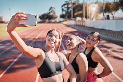 Buy stock photo Fitness, selfie and athletes training on a track for a marathon for health, wellness and exercise. Sports, smile and happy friends taking a picture with a smartphone after a workout on a field.
