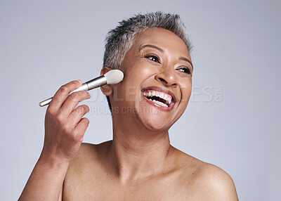 Buy stock photo Senior woman, makeup and brush in studio isolated on a gray background. Skincare, self care and mature female model from India apply cosmetics product with makeup brush for beauty and healthy skin.
