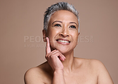 Buy stock photo Face, beauty and skincare with a mature model woman in studio on a brown background thinking about wellness. Luxury, cosmetics and antiaging with a senior female posing to promote a skin product