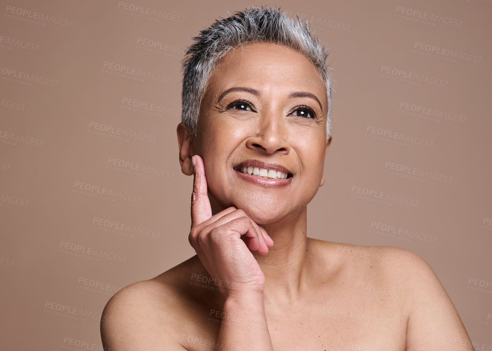 Buy stock photo Face, beauty and skincare with a mature model woman in studio on a brown background thinking about wellness. Luxury, cosmetics and antiaging with a senior female posing to promote a skin product