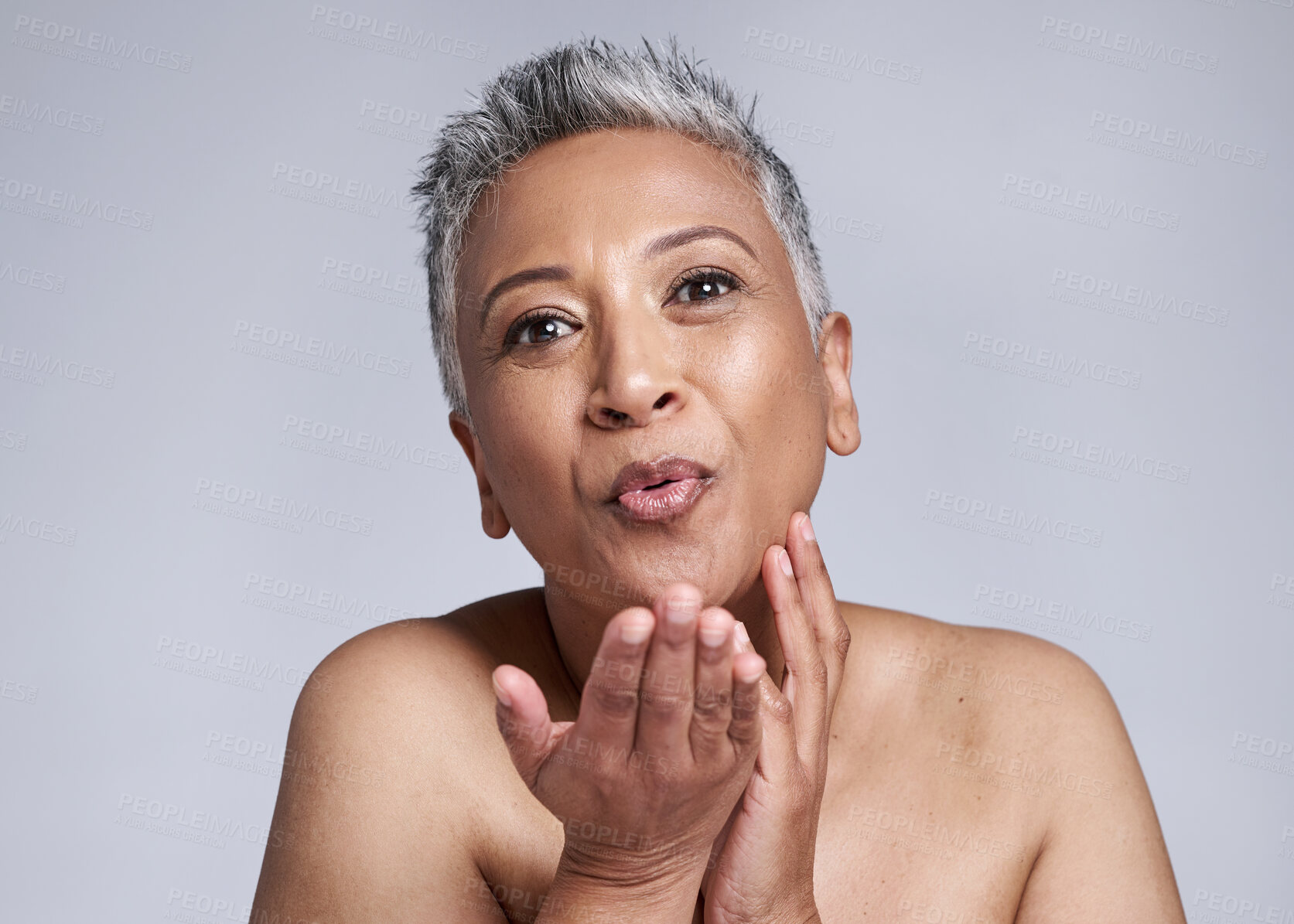 Buy stock photo Beauty, mature woman blowing a kiss and cosmetics in studio background portrait. Skincare, happy senior lady kissing air and sending love in celebration of life, wellness and happiness in retirement.
