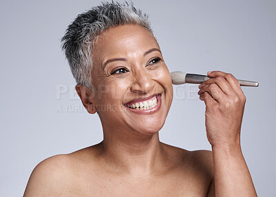 Buy stock photo Brush, makeup and happy old woman in studio for a cosmetics, skincare beauty or luxury facial grooming. Smile, senior and excited face model enjoys applying foundation products in a self care routine