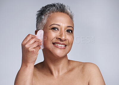Buy stock photo Portrait, happy and senior woman gua sha, face and smile in grey studio background. Elderly woman, skincare model and wellness care of healthy skin with facial treatment with beauty cosmetic tool