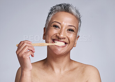 Buy stock photo Mature woman, toothbrush and brushing teeth on studio background, morning grooming routine or healthcare wellness. Portrait, smile or beauty model in dental care cleaning or happy hygiene maintenance