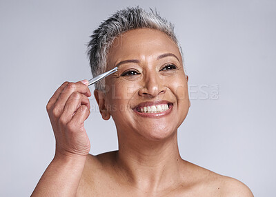 Buy stock photo Beauty, eyebrow and hair removal of a senior woman in studio for skincare, cosmetics and makeup with a smile, happiness and glow. Mature model with tweezers for removing facial hair for clear skin