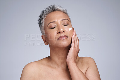 Buy stock photo Senior woman, cream and skincare for health, wellness and hand touching smooth face against grey studio background. Elderly model, beauty and cosmetic lotion, advertisement and sunscreen with mockup