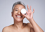 Skincare, beauty and happy woman with face cream for her skin routine with natural product in a studio. Happiness, smile and portrait of a senior lady with facial lotion isolated by a gray background