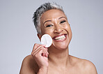 Happy senior woman, portrait cotton for skincare and cleaning face in facial dermatology. Remove makeup with pad, elderly lady in studio with gray background and natural headshot for spa mock up