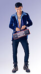 Fashion, makeup and radio with an lgbt man model in studio on a purple background for gay pride or music. Style, trendy and transgender with an androgynous male listening to audio in fancy clothes