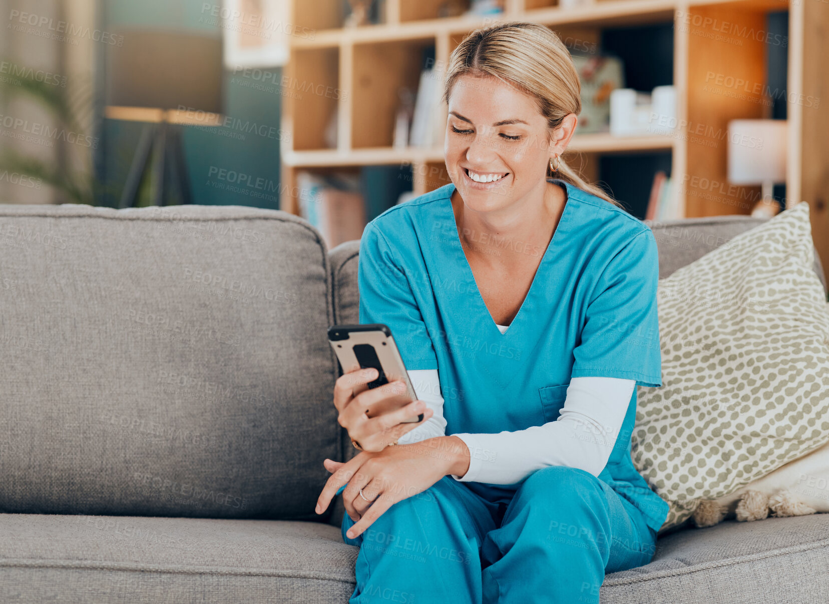 Buy stock photo Nurse, phone and happy with social media, post or funny meme on sofa in home. Woman with healthcare, medical and wellness app on mobile technology or search internet, reading news and text contact