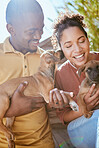 Pet, face lick and couple with dogs playing, having fun and enjoy quality time together in home backyard. Animal love bond, happiness and owner pet care from happy black woman and man with new puppy