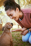 Black woman, puppy and happy with smile, playful and being loving outdoor on grass. Love, African American female and girl with small pet, dog and canine for bonding, happiness and have fun outside.