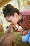 Kiss, dog and adoption with a black woman at a rescue shelter looking for a foster animal to love or care for. Kissing, love and pet with a young female adopting a puppy from a shelter to rehome