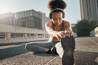 Buy stock photo Stretching, foot and city black woman on floor with headphones, sneakers and training gear for outdoor running, exercise and workout. Sports, fitness and girl listening to music for muscle warmup