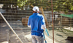 Volunteer, charity and animal shelter with a black man working at a rescue center for the adoption of foster pets. Worker, community and care with a male employee at work alone with rescue animals