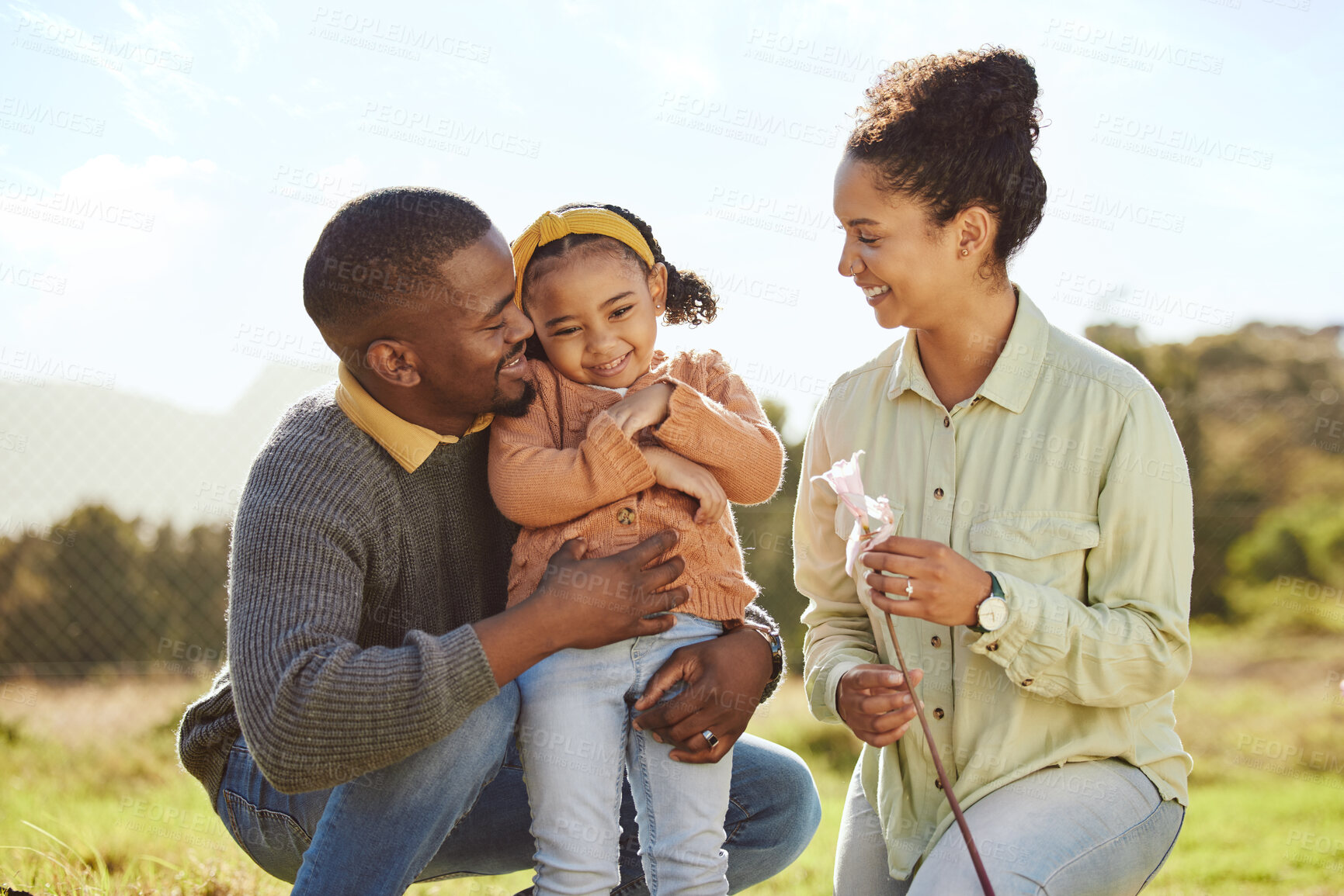 Buy stock photo Happy family, hug and nature with a mother, father and girl on an outdoor adventure in a green park. Black family, smile and travel of a mom, man and child bonding on a countryside field in spring