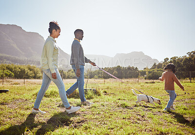 Buy stock photo Nature, pet and black family taking a walk with dog having fun, bonding and enjoying summer. Love, animals and mom and dad walking with young girl and puppy in park on weekend, holiday and vacation