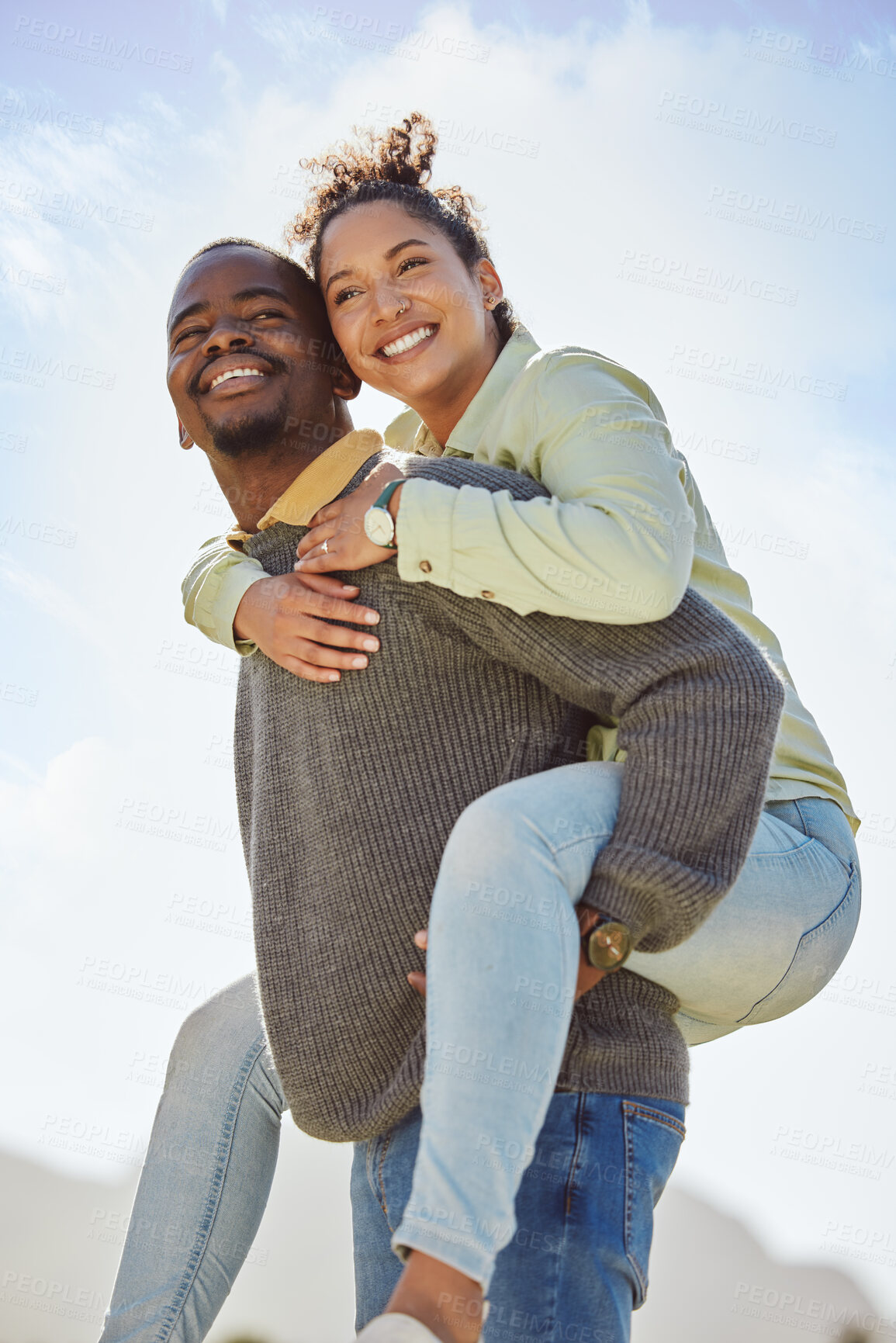 Buy stock photo Happy, couple and piggy back enjoy fresh air on vacation outdoor with blue sky background. Smile, black man and happiness woman being playful and having fun together on a romantic date in nature park