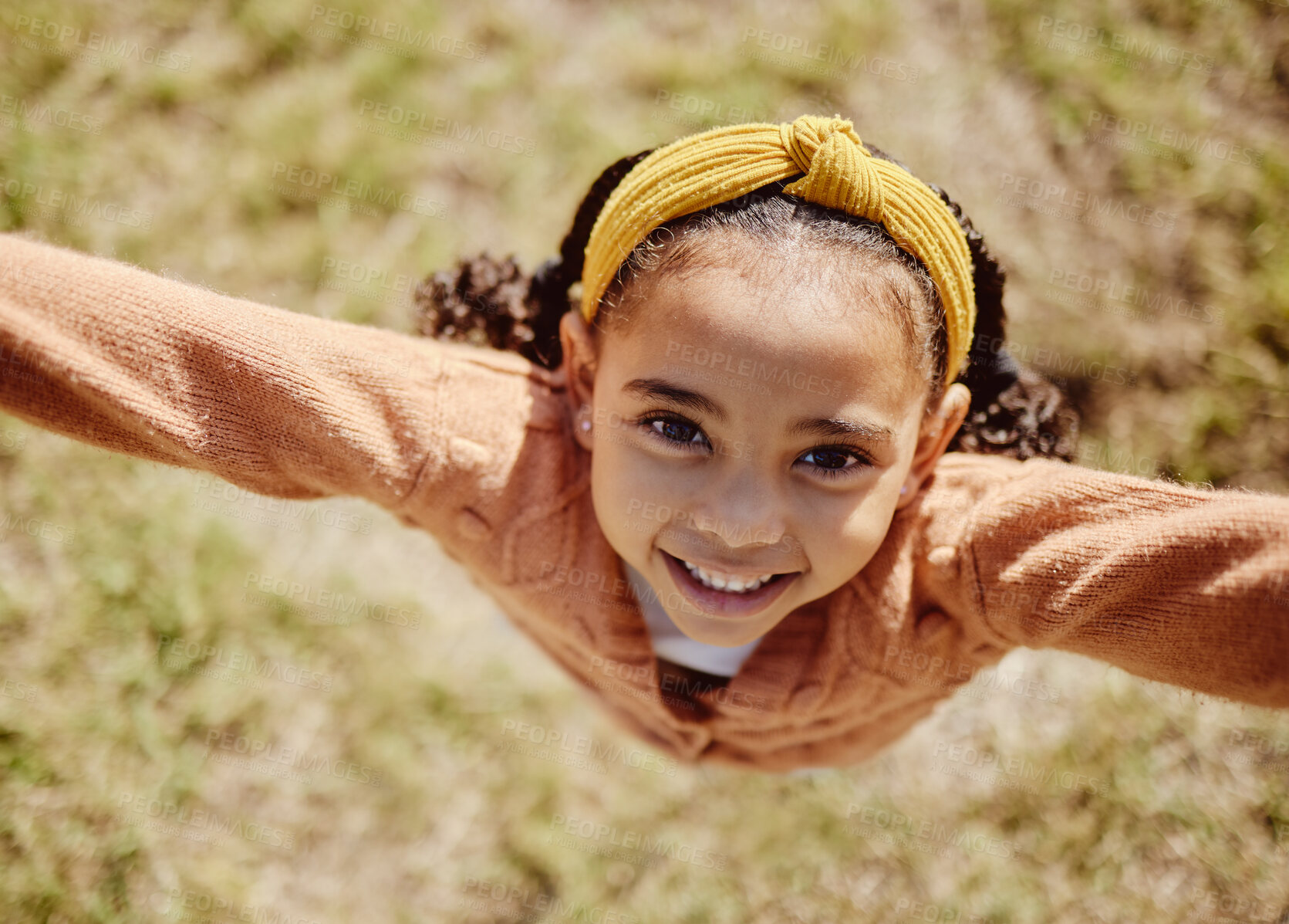 Buy stock photo Top view, child or girl in fun game pov in nature park, garden environment or sustainability grass field in summer break. Portrait, smile or happy youth kid playing or jumping or in energy activity