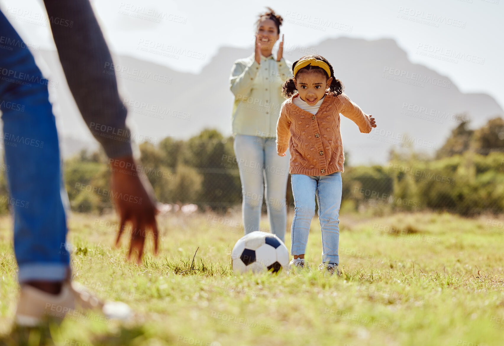 Buy stock photo Parents, park and girl kick soccer ball for fun sports learning, bonding and relax in sunshine, garden and nature together. Happy family, little girl and black people playing football on grass field 