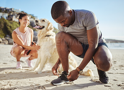 Buy stock photo Fitness, walk and couple at the beach with their dog for freedom, exercise and relax during summer. Wellness, nature and black man tying shoelace by the sea before running with his pet and girlfriend
