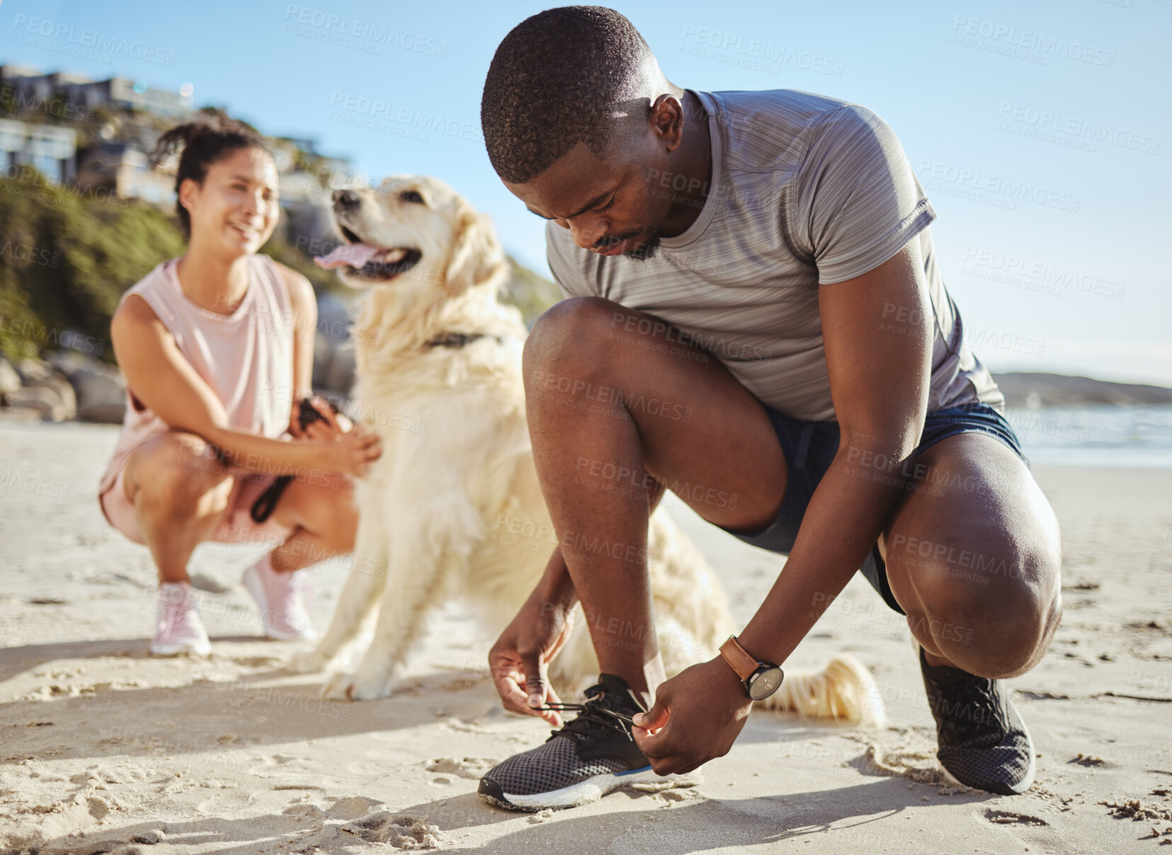 Buy stock photo Fitness, walk and couple at the beach with their dog for freedom, exercise and relax during summer. Wellness, nature and black man tying shoelace by the sea before running with his pet and girlfriend