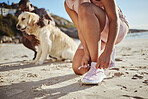 Fitness, exercise and tying shoelace on running shoes while outdoor at the beach for a workout, training and cardio in nature. Hands of an athlete woman with sneakers while out for a run on sand