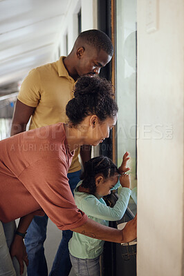 Buy stock photo Family, love and animal shelter with a girl, mother and father looking through a window together in a pet store. Charity, kids and community with a woman, man and daughter at an adoption center