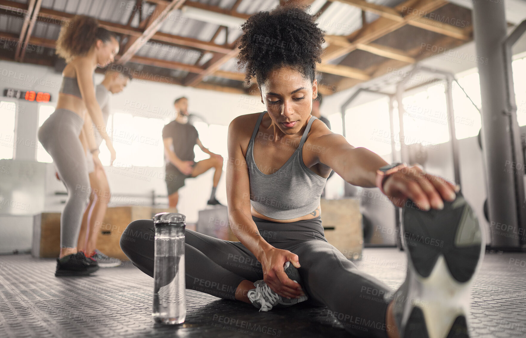 Buy stock photo Black woman, fitness and stretching in gym to workout, exercise or training for health, self care and wellness. Woman, legs and warm up for energy with sports shoes, focus and strong body performance