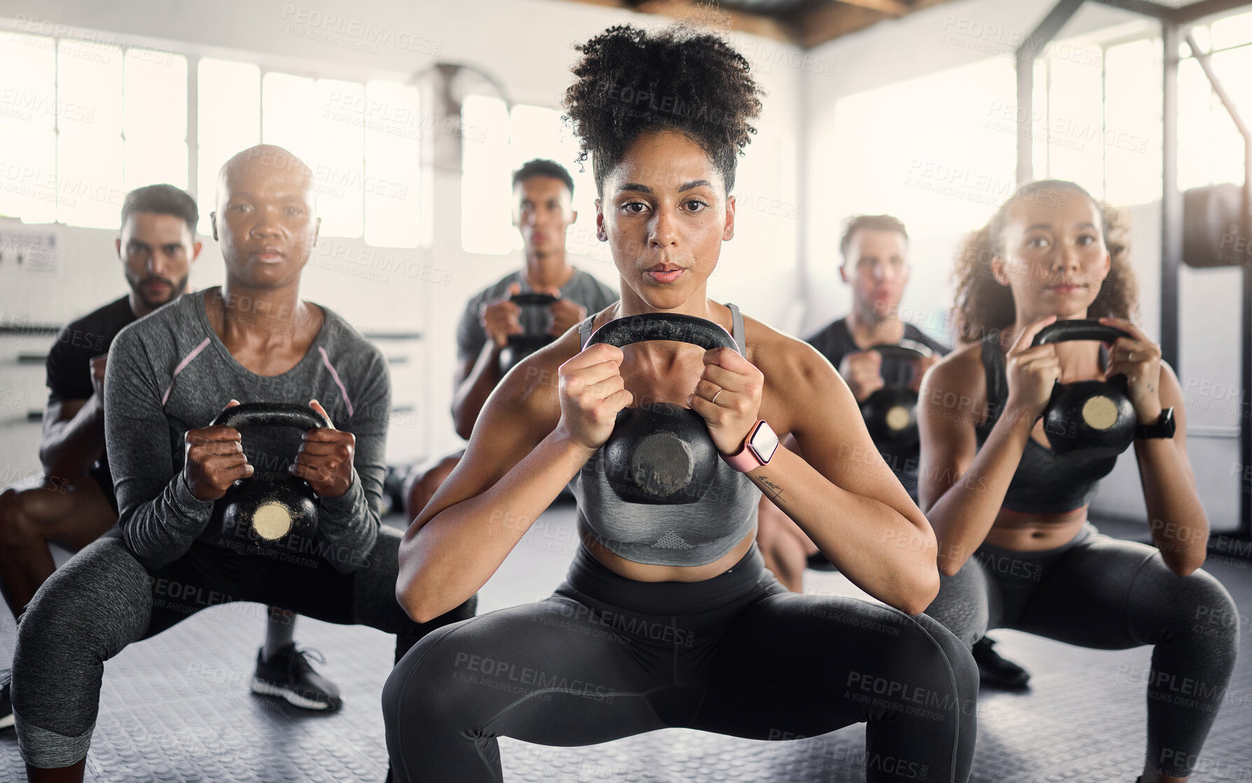 Buy stock photo Fitness, kettle bell and gym class with a black woman coach training an athlete group in an exercise center. Workout, health and wellness with a man and woman team exercising in a sports facility