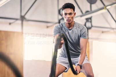 Buy stock photo Gym battle ropes, training and black man athlete in a cardio, workout and sports exercise. Man in a wellness rope and health club with power, energy and strong muscle doing fitness and trainer lift