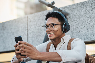 Buy stock photo Music, phone and city with a business black man streaming or listening to music while networking. Schedule, mobile and street with a male employee using headphones to stream audio in an urban town