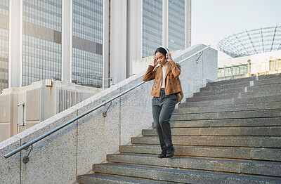 Buy stock photo Music, stairs and city with a business black woman walking outdoor while using headphones for streaming audio. Steps, commute and listening with a female employee streaming audio in an urban town
