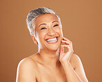 Skincare, wellness and senior woman with makeup for face with a smile and happy against a brown studio background. Beauty, portrait and elderly cosmetic model with happiness for glow in retirement