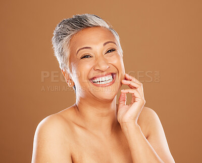 Buy stock photo Skincare, wellness and senior woman with makeup for face with a smile and happy against a brown studio background. Beauty, portrait and elderly cosmetic model with happiness for glow in retirement