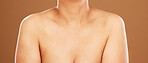 Woman, chest and skincare on a brown studio background for health, wellness and breast cancer awareness. Human body, skin and bust of a female model posing naked for healthcare and self care