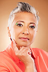 Makeup, creative and senior woman with fashion, beauty and designer luxury against a brown studio background. Stylish, retirement and portrait of elderly model with an idea for cosmetics and style