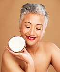 Beauty, coconut and skincare with woman in natural cosmetic product advertising against studio background. Healthy skin, fresh and clean with organic cosmetics, face and body care for antiaging.